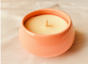 Candle in a pink holder on a beige fabric background